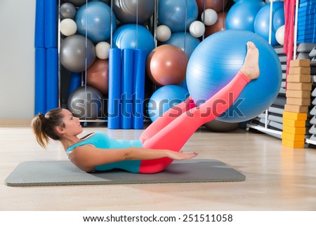 Ab exercise woman swiss ball leg lifts Pilates workout abs at gym