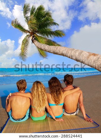 friends group couples sitting in beach sand rear view back palm tree photo mount