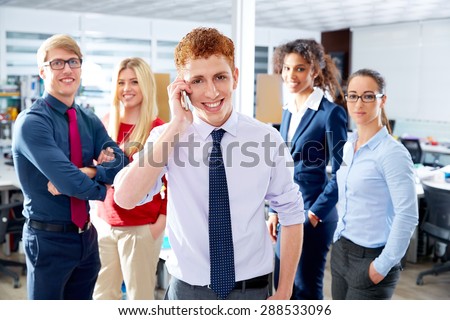 young executive talking phone in multi ethnic teamwork group as leader in office