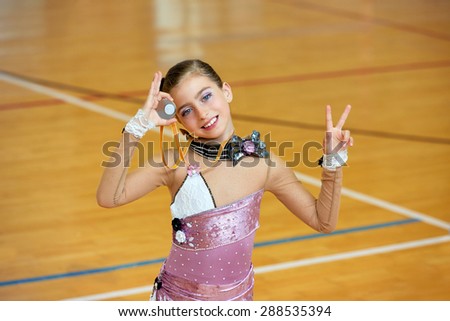 kid girl rhythmic gymnastics on wooden deck medal winner gesture