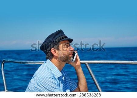 Captain cap sailor man talking mobile phone in boat sailing in the ocean sea