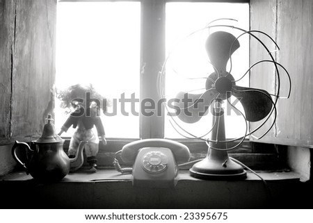Antique vintage air fan, doll and phone at the window back-light