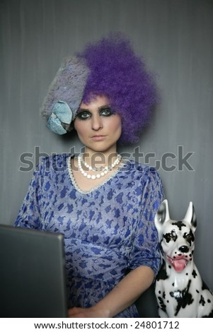 extreme contemporary fashion woman with computer and dalmatian dog, purple wig
