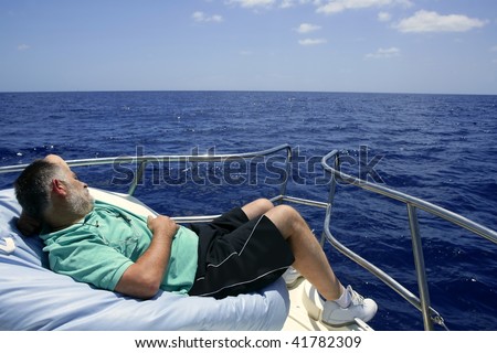 Sailor senior man having a rest on summer boat over blue ocean