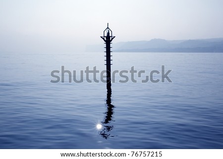 back light navigation beacon in Mediterranean blue sea water reflection