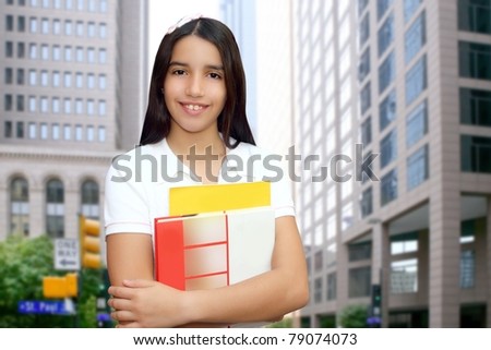 Brunette student young girl teen latin holding books modern city buildings [Photo Illustration]