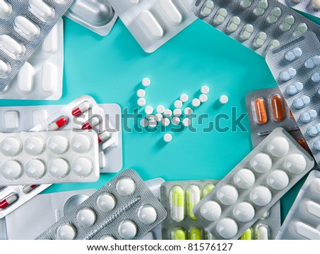 blisters of medical pills over green background as a pharmaceutical industry concept