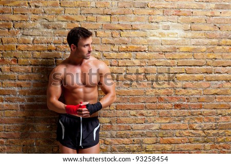 muscle boxer shaped man with fist bandage in red and black on brick wall