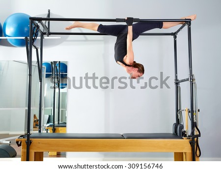 Pilates woman in cadillac walk over reformer upside down exercise at gym