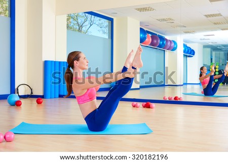 Pilates woman open leg rocker exercise workout at gym indoor