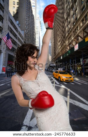 Young girl in boxing gloves trying to get a taxi.