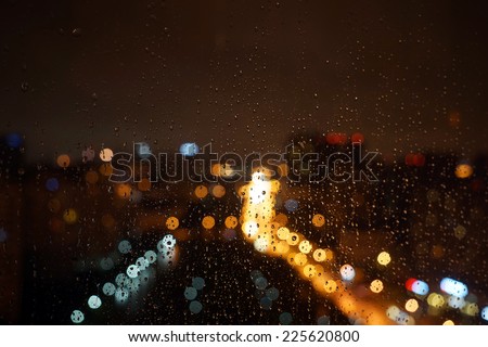 Wet the window with the background of the night city traffic view.