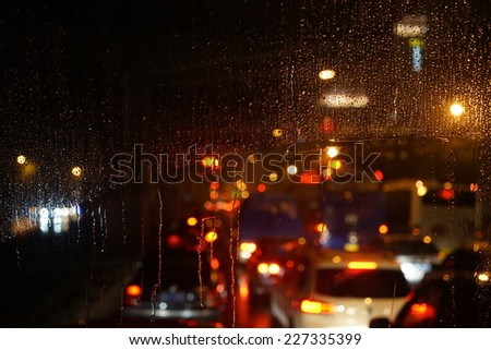 Wet the car window with the background of the night city traffic view.