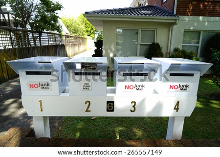 White metallic mailboxes outside of the house.