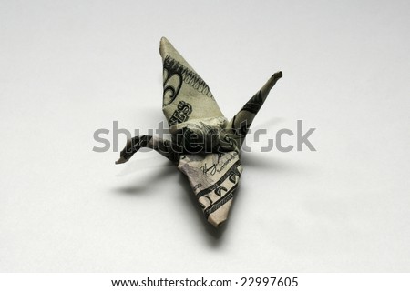 An origami crane made from a five-dollar bill represents money\'s ability to seemingly just fly away