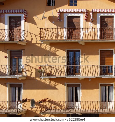Nne doors, sixbalconies, orange Italian facade with blinds Stock fotó © 