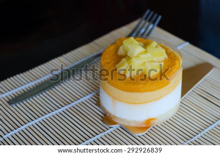 Close up of mango mousse cake on yellow background