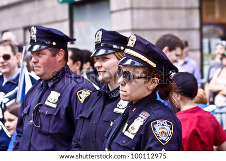 NEW YORK - APRIL 14:  Three officers of The NYPD watch as The Scotland Week Parade on 6th Avenue continues on April 14, 2011 in New York, NY.
