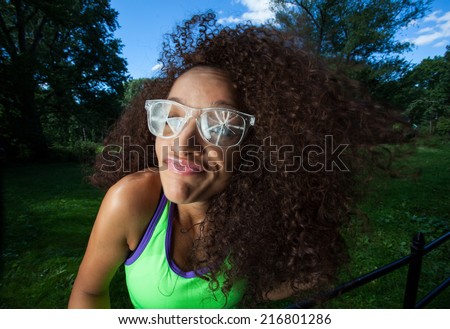 Young Brunette Hispanic woman wearing broken glasses and making silly faces in Central Park, NYC