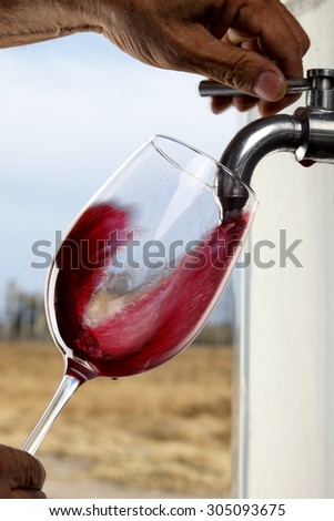 glass of red wine vineyard tap