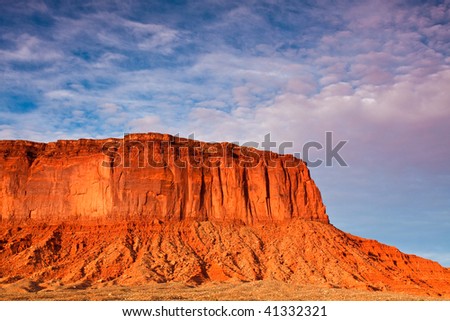 Sunlit Mesa and Dramatic Sky in Monument Valley, Utah.