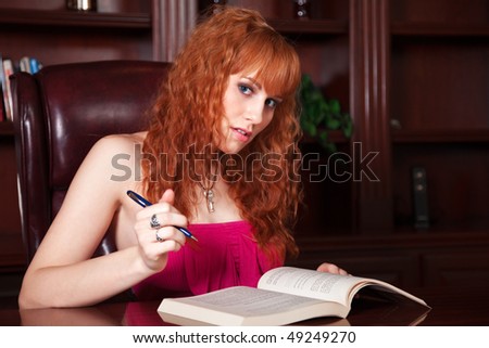 Attractive Redhead Woman Reading a Book in a Luxury Study Room.