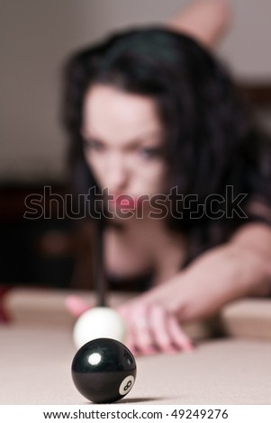 Sexy Female Taking a Shot at the Eight Ball in a Game of Pool. Focus on the 8 Ball.
