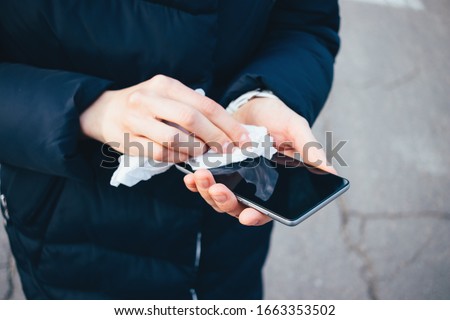 Similar – Image, Stock Photo Woman disinfecting phone with antiseptic wet wipe. Antiseptic napkin to prevent spread of germs, bacteria and coronavirus. Coronavirus prevention. Prevent illness coronavirus after public place.