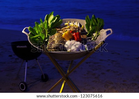 Beach seafood barbecue ingredients at sunset