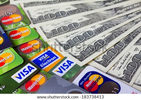 KIEV, UKRAINE - March 22: Pile of credit cards, Visa and MasterCard, credit, debit and electronic with US dollar bills, in Kiev, Ukraine, on March 22, 2014. Selective focus.
