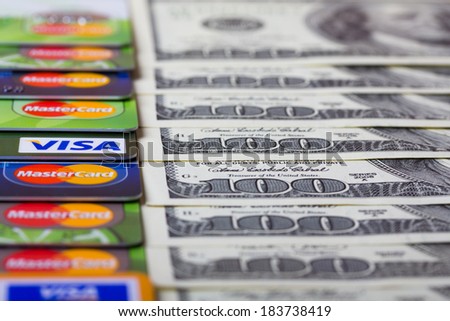 KIEV, UKRAINE - March 22: Pile of credit cards, Visa and MasterCard, with US dollar bills, in Kiev, Ukraine, on March 22, 2014. Selective focus.
