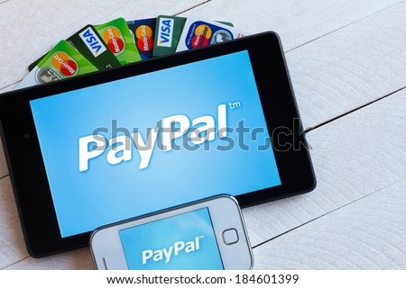 KIEV, UKRAINE - March 29: PayPal payment system logo on tablet and smarphone with plastic payment cards, Visa and MasterCard, in Kiev, Ukraine, on March 29, 2014.