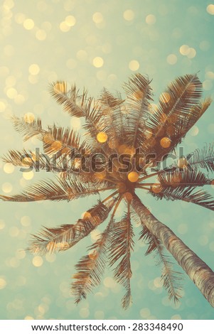 Vintage color stylized palm tree with bright party bokeh light overlay, double exposure effect