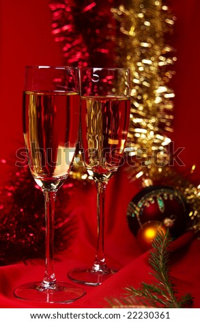 Happy New Year!!! Two wine glasses with champagne on a red background