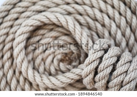 Braided thick rope tied in a skein. Hemp rope for decoration and design. Background from fishing rope. Foto stock © 