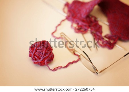 red ball of yarn knitting needles to knit socks