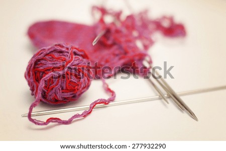 red ball of yarn knitting needles to knit socks