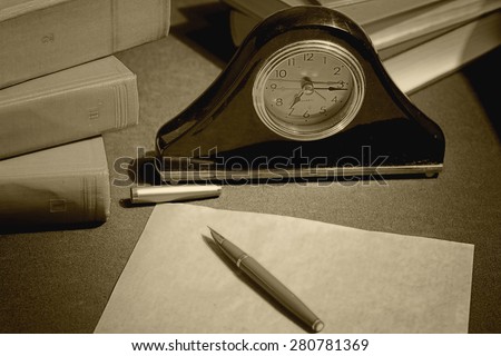 work desk clock pen book paper
