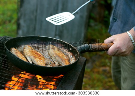 fish frying in oil on the fire