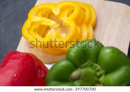 The yellow sweet pepper cut on a wooden cutting board.
