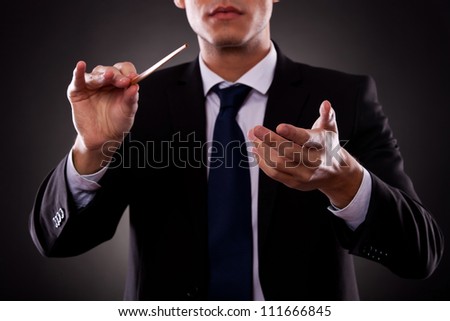 Cutout picture of a young orchestra conductor directing with his baton