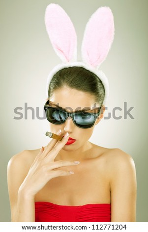 sexy bunny woman wearing sunglasses smoking on a big cigar - vintage picture style