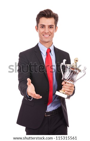 business man handing a trophy and is ready to handshake with the champion