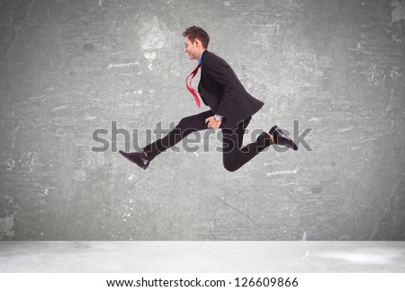 young business man in a big run over a gray background