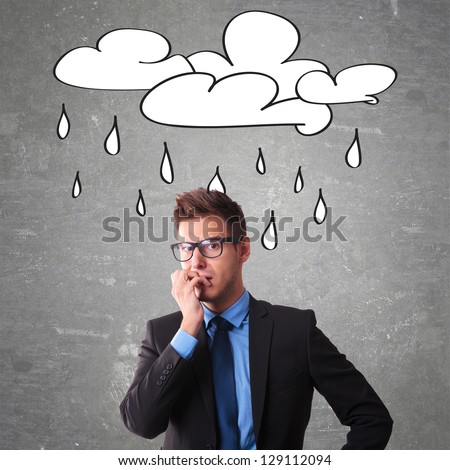 Worried office worker with a cloud drawn on a blackboard over his head