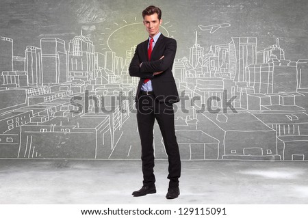 confident young business man standing in front of a sketch of a big city