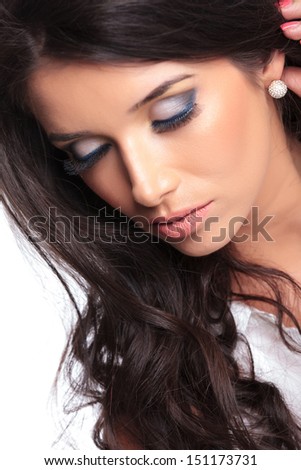 closeup photo of a young beautiful woman keeping her eyes shut and her hand behind her ear. isolated on a white background