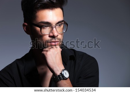 closeup photo of a young fashion man looking away with a thoughtful expression. isolated on a gray background