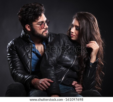 fashion man and woman looking at each other with love on dark background