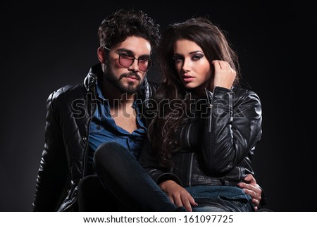 fashion couple in leather jackets posing for the camera on dark background